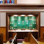Cable Suspended Glass Shelf Display Showcasing Relics from Catholic Giants at Holy Family Columbus