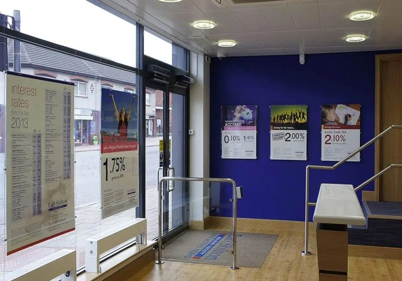 C1006 — Cable Suspended Easy Access Acrylic Poster Display in Bank Office Setting C1006 — Cable Suspended Easy Access Acrylic Poster Display in Bank Office Setting