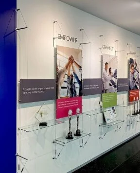 C1035 — Cable Suspended Recognition Wall Display with Graphics, Signage and Shelves C1035 — Cable Suspended Recognition Wall Display with Graphics, Signage and Shelves